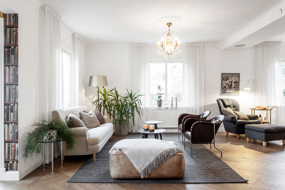 Mid-sized traditional formal open concept living room in Gothenburg with white walls, medium hardwood floors, no fireplace, no tv and brown floor.