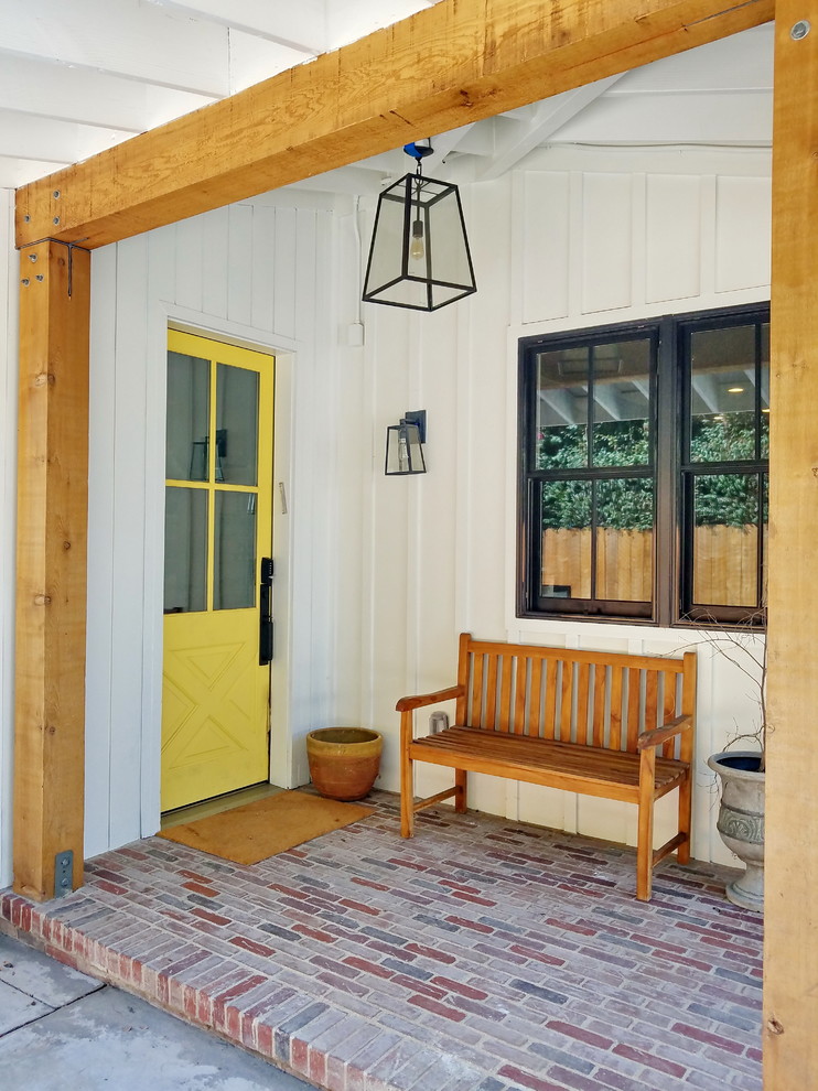 Photo of a traditional front yard verandah in Los Angeles with brick pavers and a roof extension.