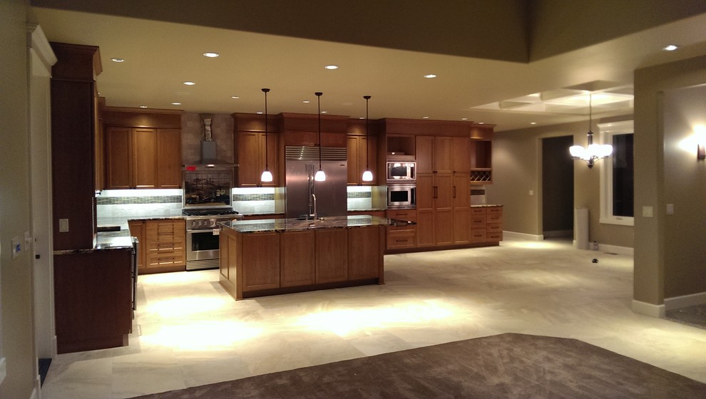 Photo of an arts and crafts l-shaped eat-in kitchen in Seattle with an undermount sink, recessed-panel cabinets, medium wood cabinets, granite benchtops, beige splashback, ceramic splashback and stainless steel appliances.