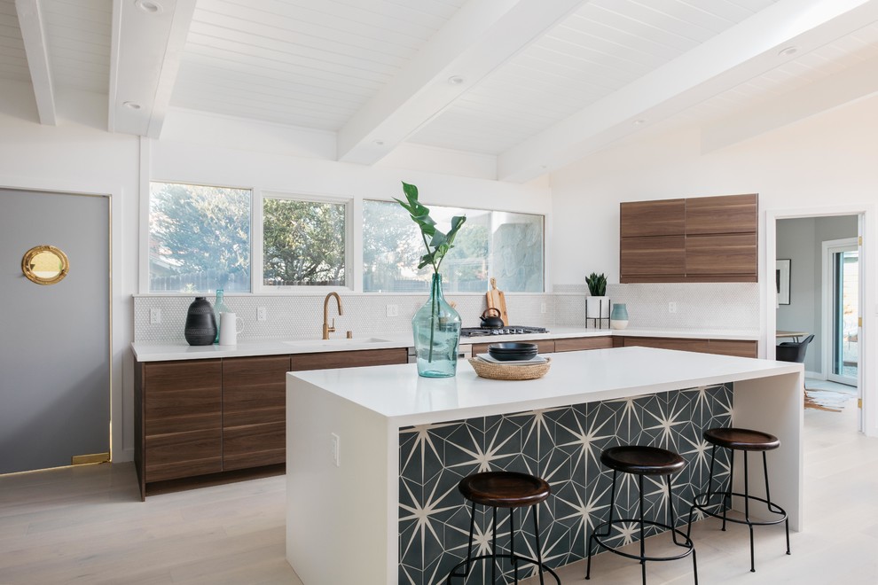 Inspiration for a midcentury l-shaped open plan kitchen in Los Angeles with an undermount sink, flat-panel cabinets, brown cabinets, grey splashback, stainless steel appliances, light hardwood floors, with island, beige floor and white benchtop.