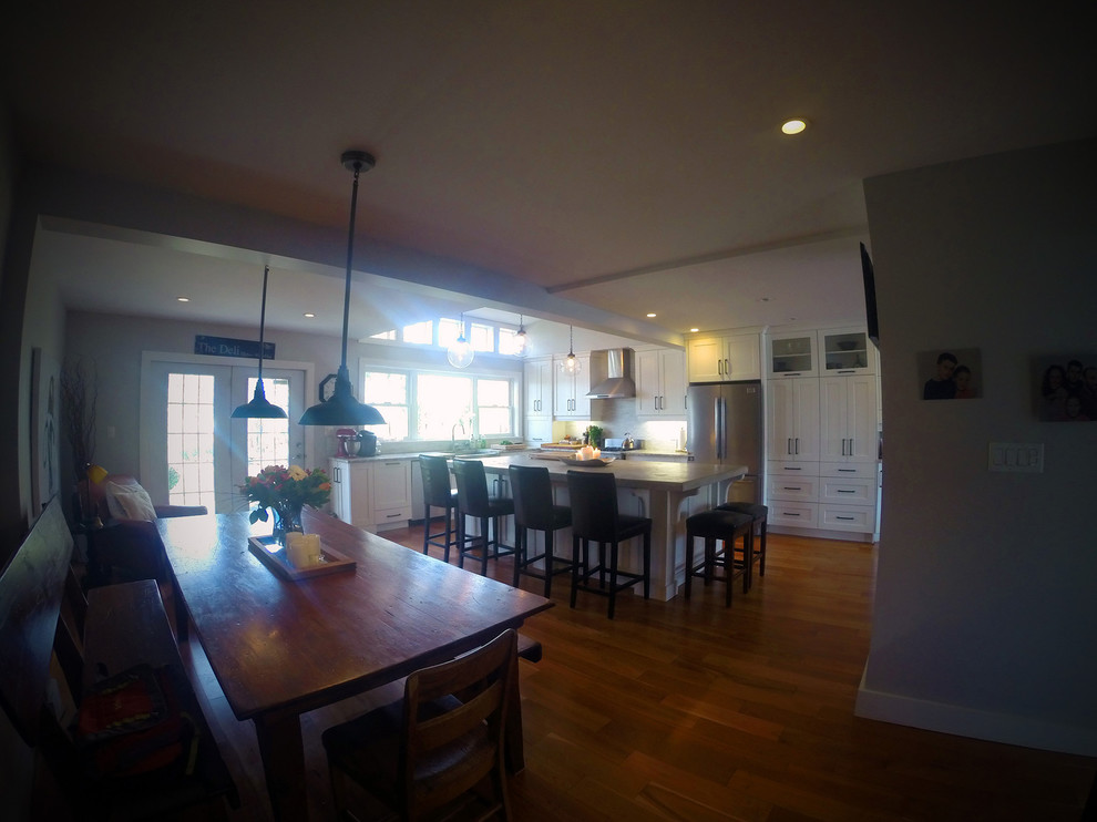 Mid-sized transitional u-shaped medium tone wood floor eat-in kitchen photo in Toronto with shaker cabinets, white cabinets, stainless steel appliances and an island