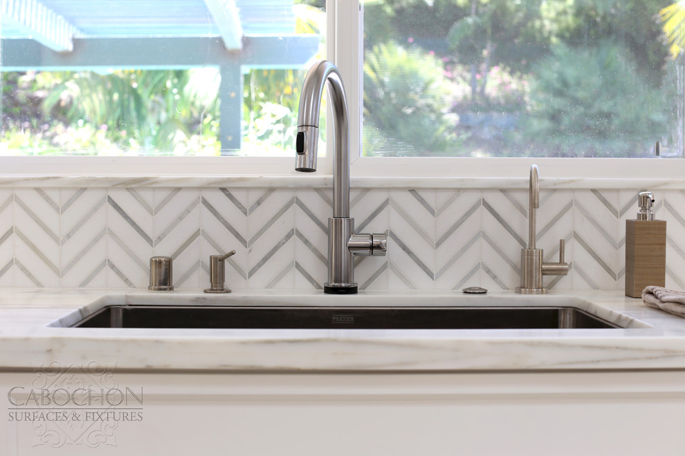 Mid-sized transitional l-shaped limestone floor open concept kitchen photo in San Diego with an island, shaker cabinets, white cabinets, marble countertops, white backsplash, mosaic tile backsplash, stainless steel appliances, an undermount sink and beige walls