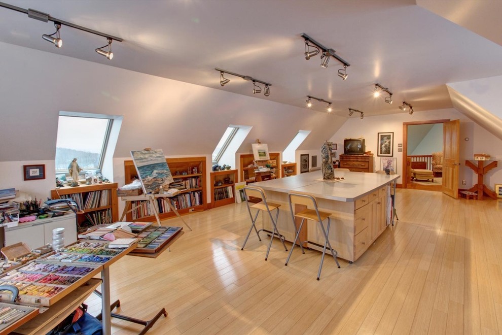 Photo of a large arts and crafts home studio in New York with light hardwood floors and a freestanding desk.