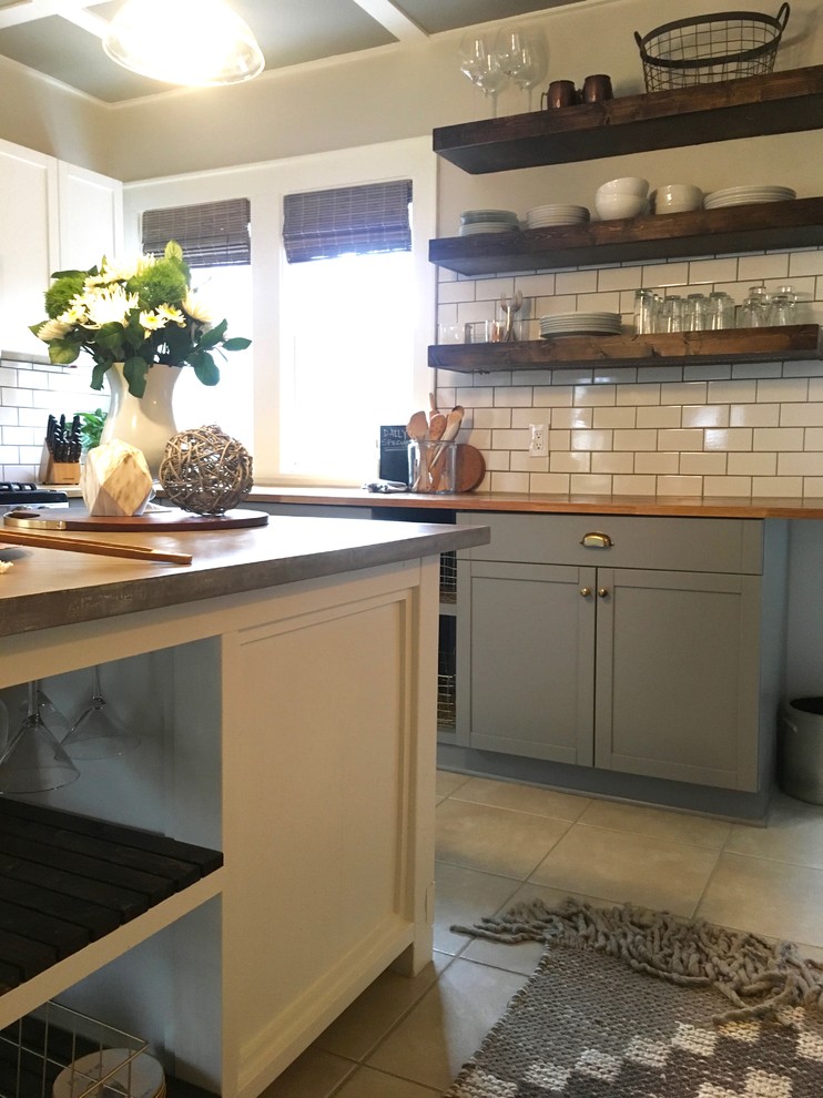 This is an example of a large transitional l-shaped separate kitchen in Cleveland with a farmhouse sink, shaker cabinets, grey cabinets, concrete benchtops, white splashback, subway tile splashback, stainless steel appliances, ceramic floors and with island.