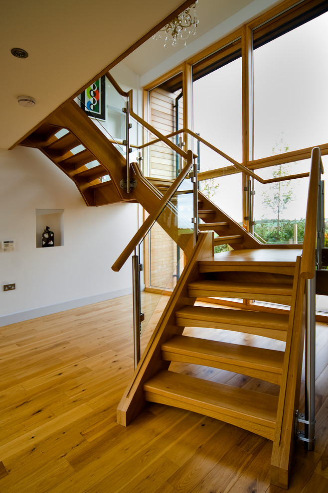 Large modern wood floating staircase in London with open risers.