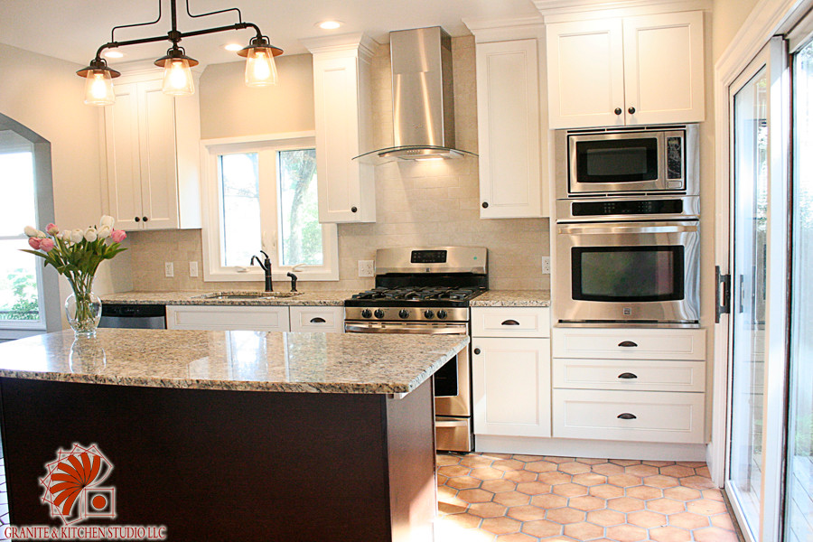 Bild på ett stort vintage linjärt kök och matrum, med en undermonterad diskho, skåp i shakerstil, vita skåp, granitbänkskiva, beige stänkskydd, stänkskydd i stenkakel, rostfria vitvaror, klinkergolv i terrakotta och en köksö