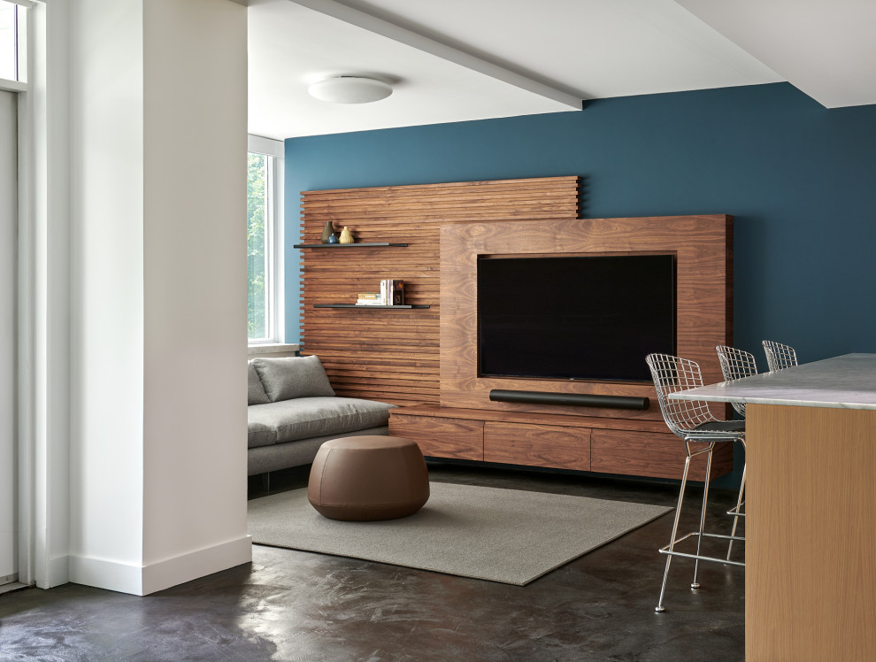 Imagen de salón abierto actual pequeño con paredes azules y pared multimedia