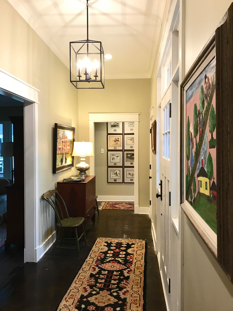 Photo of an arts and crafts hallway in New Orleans with beige walls and concrete floors.