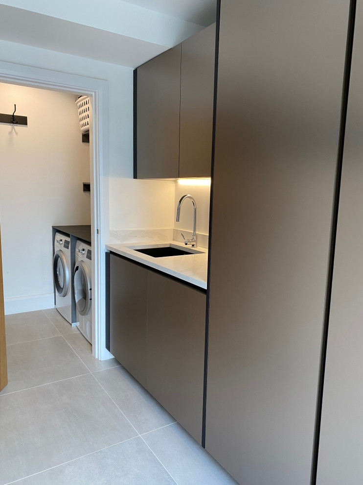 Design ideas for a large contemporary galley utility room in Manchester with a submerged sink, flat-panel cabinets, black cabinets, quartz worktops, porcelain flooring, grey floors and white worktops.