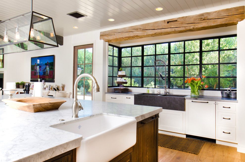 Inspiration for a country l-shaped open plan kitchen in Phoenix with a farmhouse sink, shaker cabinets, white cabinets, medium hardwood floors and with island.