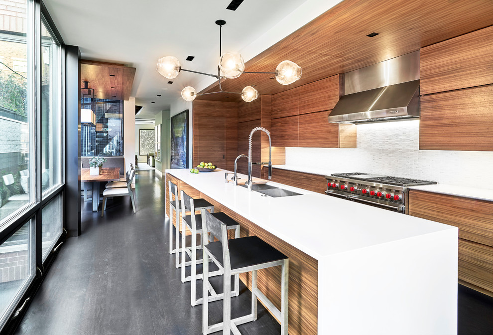 Photo of a mid-sized contemporary eat-in kitchen in Chicago with a double-bowl sink, flat-panel cabinets, medium wood cabinets, solid surface benchtops, white splashback, ceramic splashback, stainless steel appliances, with island and dark hardwood floors.
