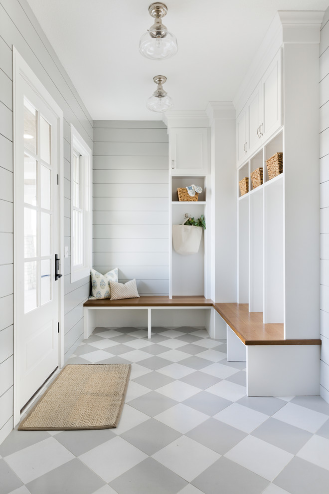Inspiration for a large beach style mudroom in Minneapolis with grey walls, ceramic floors, a single front door, a white front door and grey floor.