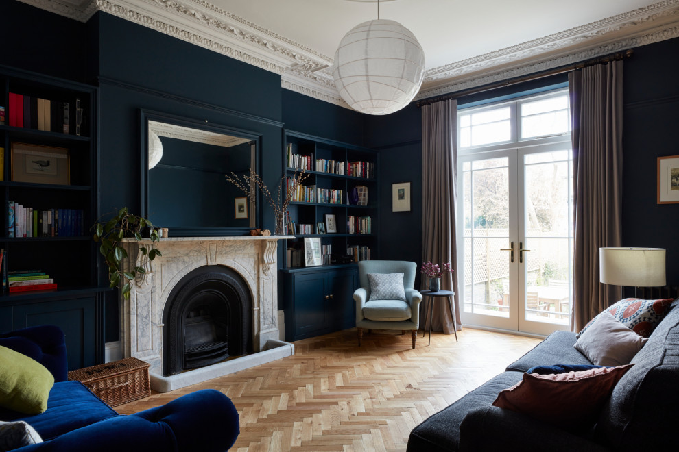 Aménagement d'un grand salon victorien avec un mur bleu, un sol en bois brun et une cheminée standard.
