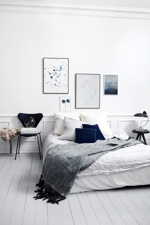 Soveværeles med smukke hvide højepaneler og hvide gulve. Kunst på væggen fra Trine Holbæk 