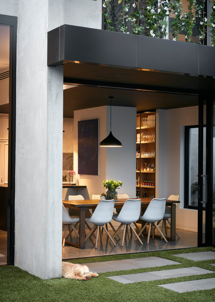 Design ideas for a contemporary separate dining room in Melbourne with white walls and concrete floors.