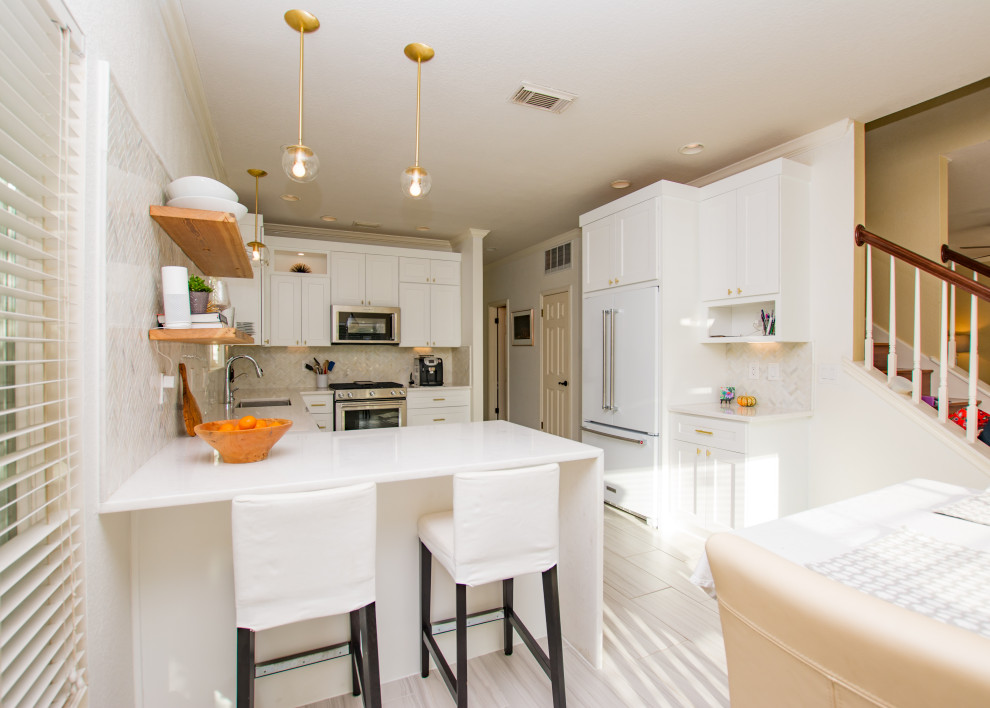 Eat-in kitchen - transitional porcelain tile and gray floor eat-in kitchen idea in Austin with an undermount sink, shaker cabinets, white cabinets, quartz countertops, white backsplash, marble backsplash, stainless steel appliances, a peninsula and white countertops