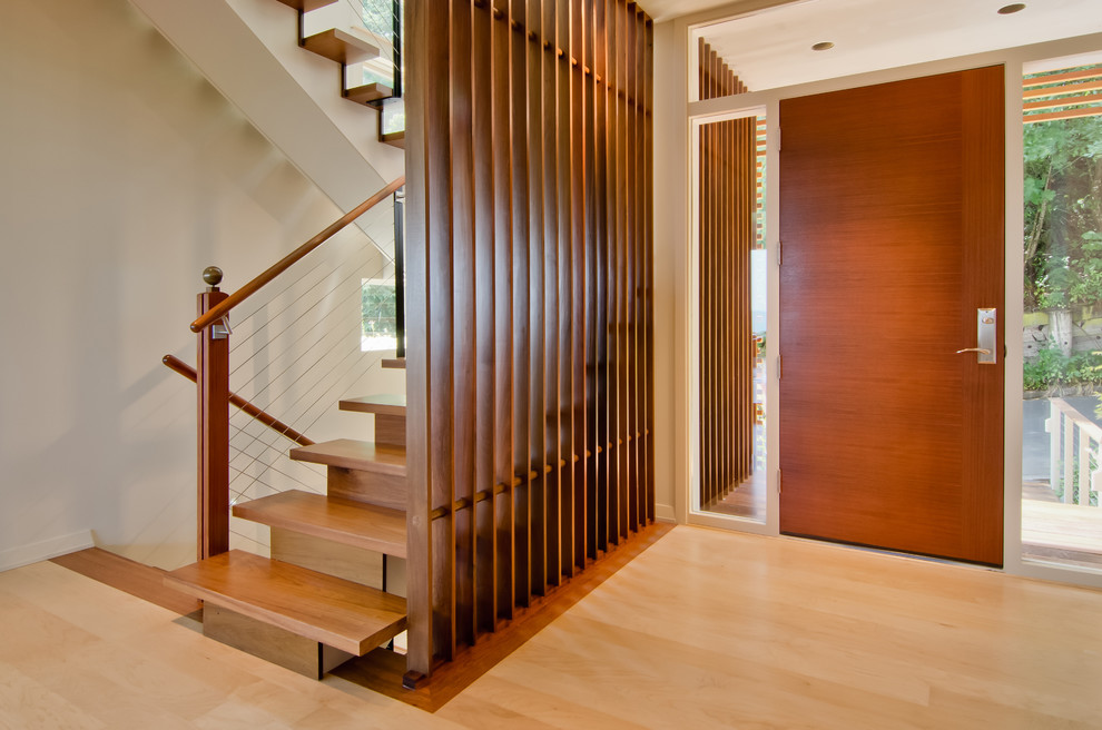 Inspiration for a mid-sized modern foyer in Portland with white walls, light hardwood floors, a single front door, a medium wood front door and beige floor.