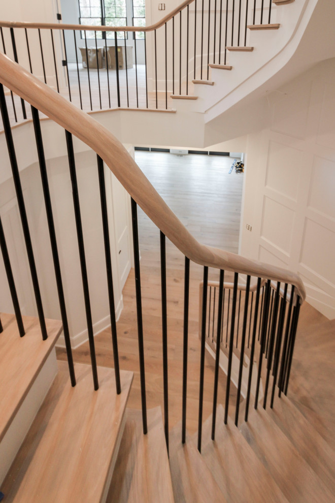 Diseño de escalera suspendida tradicional renovada grande con escalones de madera, contrahuellas de madera pintada, barandilla de varios materiales y boiserie
