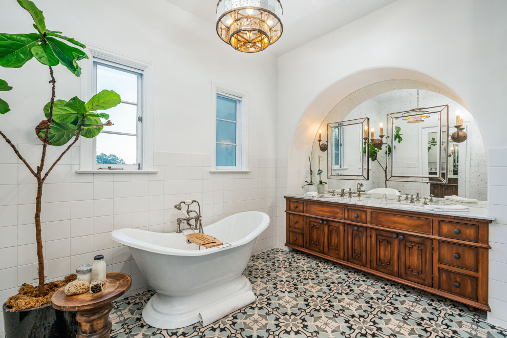 Large mediterranean master bathroom in Los Angeles with distressed cabinets, a freestanding tub, a double shower, a one-piece toilet, white tile, cement tile, white walls, cement tiles, an undermount sink, marble benchtops, blue floor, an open shower, white benchtops and beaded inset cabinets.