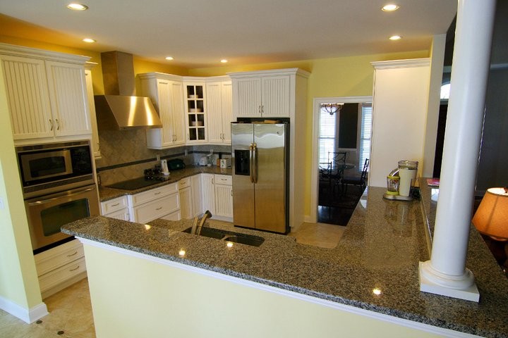 Example of a transitional kitchen design in Baltimore with white cabinets, granite countertops, stainless steel appliances and yellow walls