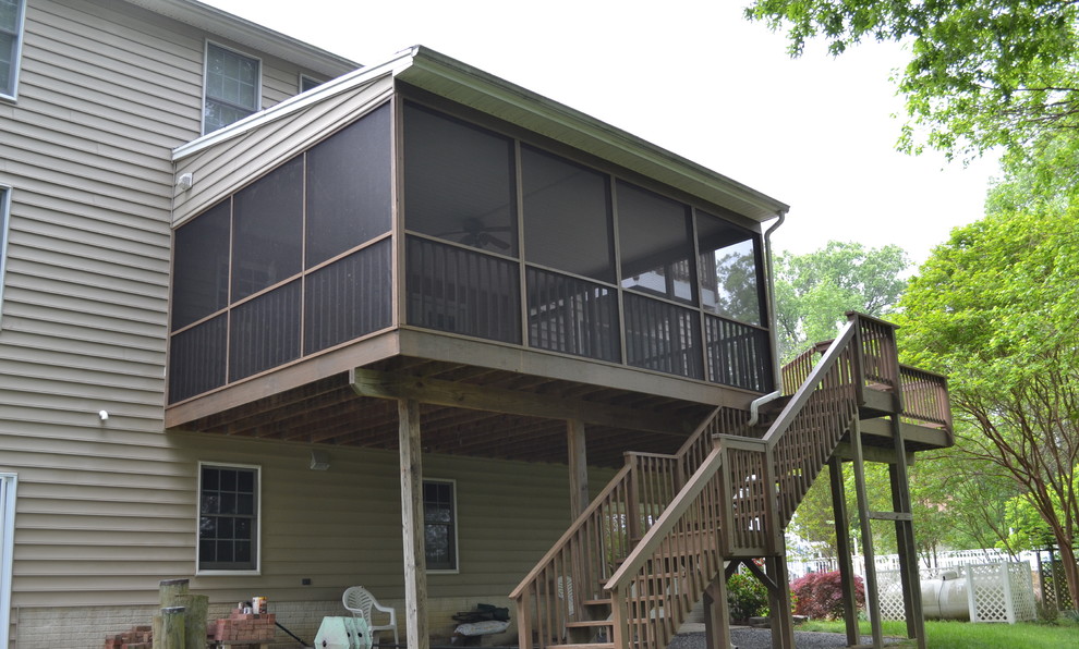This is an example of a large traditional backyard deck in DC Metro with a roof extension.