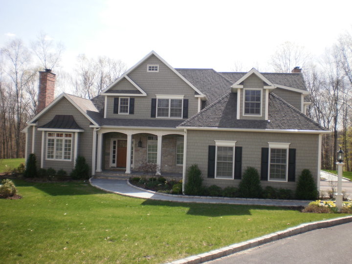 This is an example of a mid-sized traditional front yard full sun driveway in New York with concrete pavers.