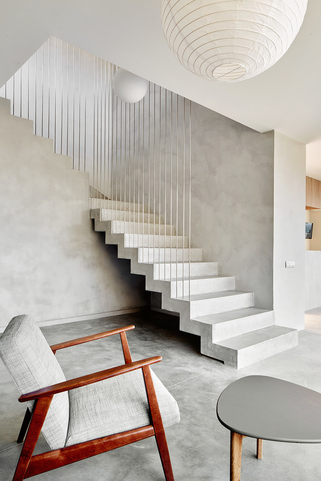 Mid-sized contemporary concrete l-shaped staircase in Other with concrete risers.