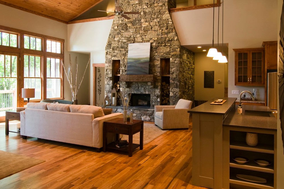 Mid-sized arts and crafts open concept living room in Other with beige walls, medium hardwood floors, a standard fireplace and a stone fireplace surround.