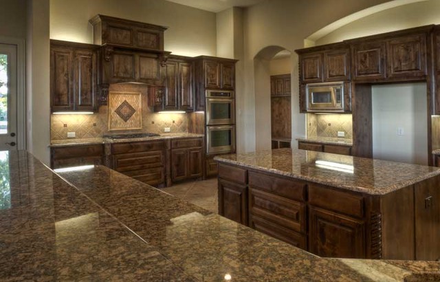 Lights above cabinets and pretty tile work around backsplash kitchen