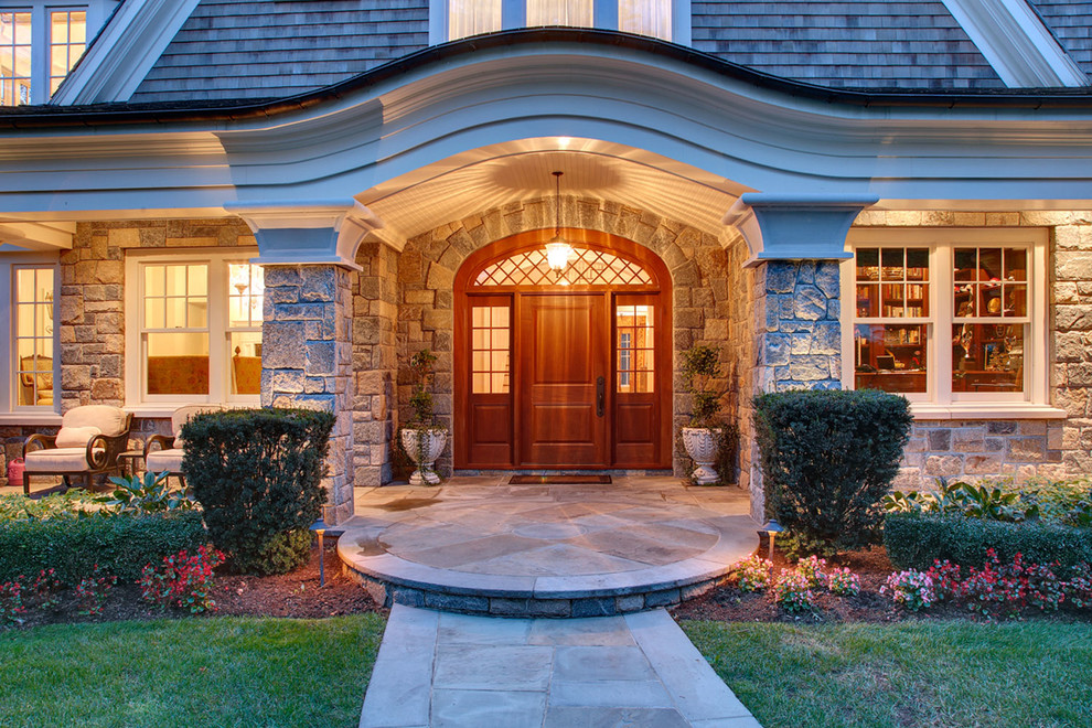 This is an example of a large traditional front door in New York with a single front door, a dark wood front door and slate floors.