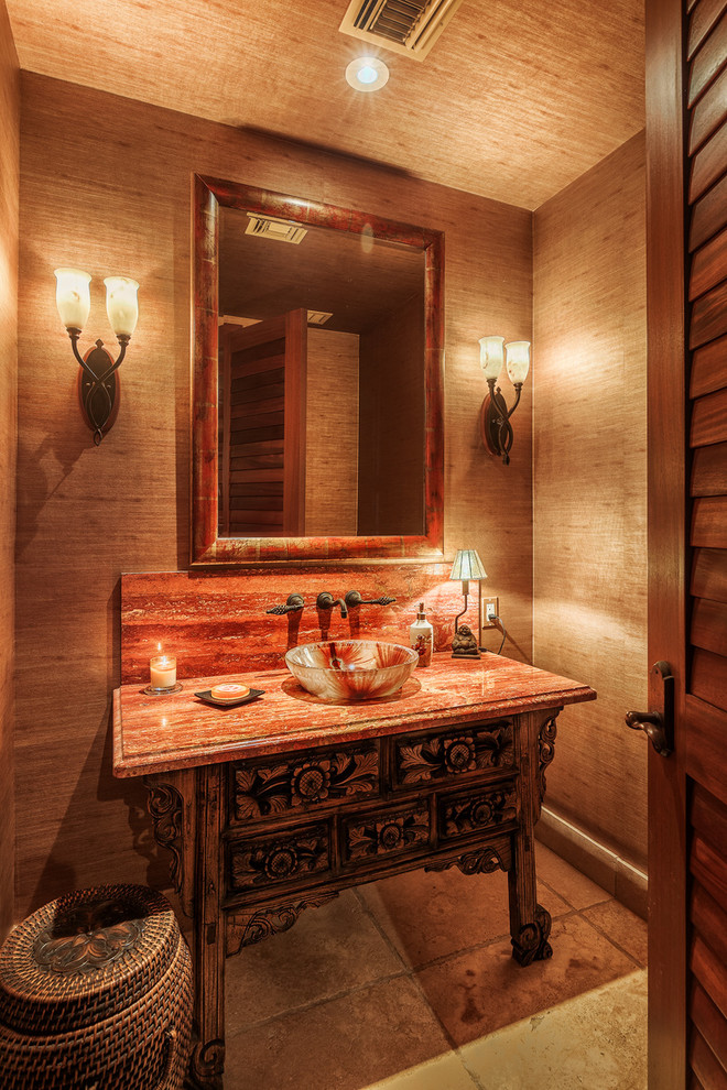 This is an example of a small tropical powder room in Hawaii with a vessel sink and solid surface benchtops.
