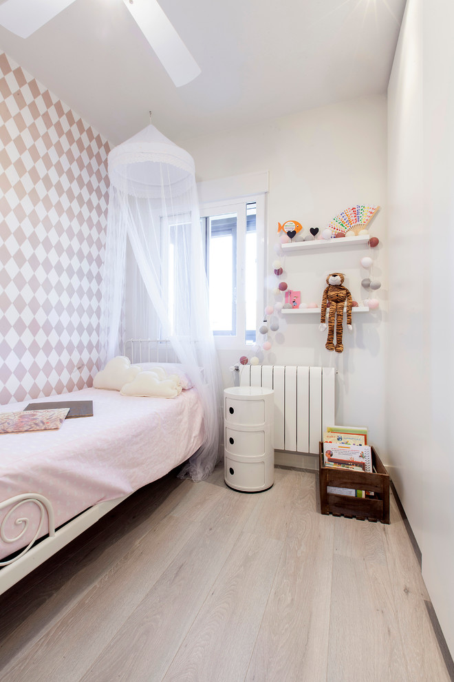 Design ideas for a mid-sized scandinavian kids' bedroom for kids 4-10 years old and girls in Madrid with white walls and light hardwood floors.