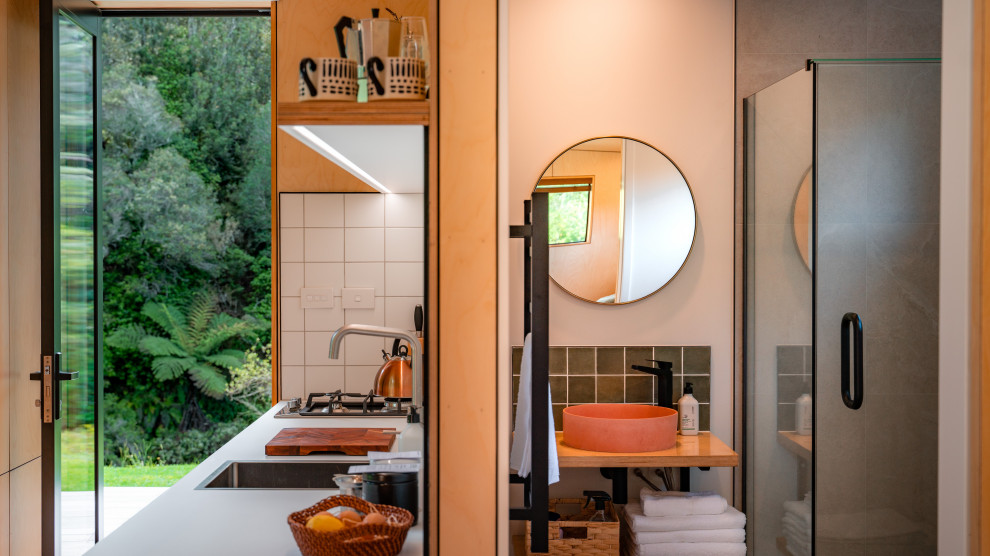 Aménagement d'une salle de bain principale craftsman avec un carrelage vert, des carreaux de porcelaine, un sol en liège, un sol marron, un plan de toilette marron, meuble simple vasque, meuble-lavabo suspendu et un plan de toilette en bois.