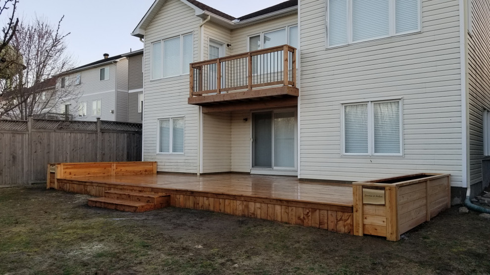 This is an example of a large modern back ground level metal railing terrace in Ottawa with skirting and no cover.