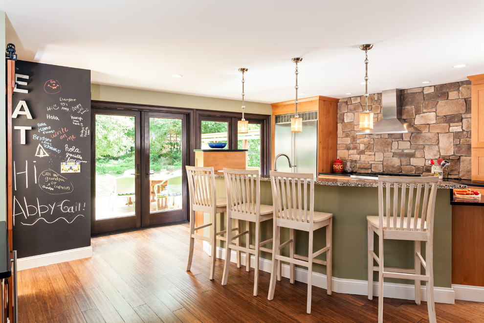 Mid-sized transitional u-shaped bamboo floor eat-in kitchen photo in Boston with an undermount sink, shaker cabinets, medium tone wood cabinets, recycled glass countertops, brown backsplash, stone tile backsplash, stainless steel appliances, green walls and an island