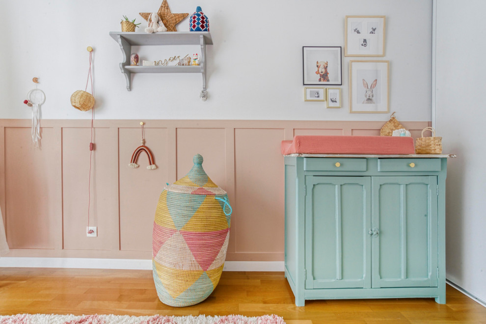 Стильный дизайн: комната для малыша среднего размера в стиле фьюжн с розовыми стенами, паркетным полом среднего тона и коричневым полом для девочки - последний тренд