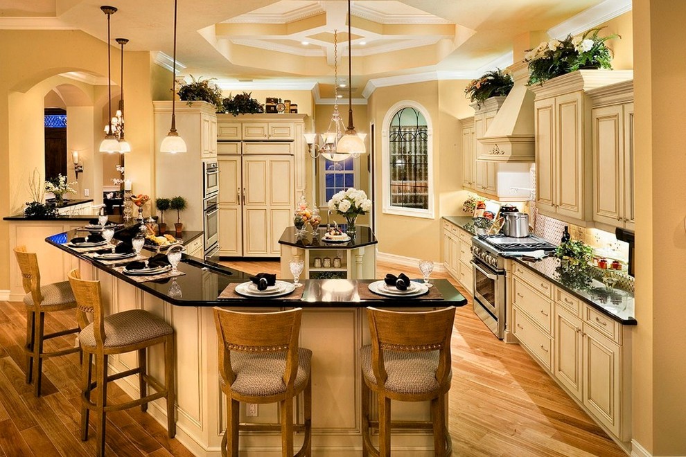 Design ideas for a large traditional single-wall separate kitchen in Miami with raised-panel cabinets, beige cabinets, a peninsula, an undermount sink, granite benchtops, panelled appliances, medium hardwood floors and brown floor.
