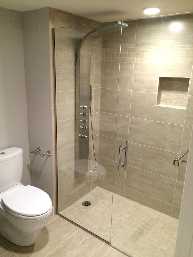 Photo of a small modern 3/4 bathroom in Boston with an alcove shower, a one-piece toilet, grey walls, ceramic floors, grey floor, a hinged shower door, flat-panel cabinets, dark wood cabinets, an integrated sink, solid surface benchtops and white benchtops.
