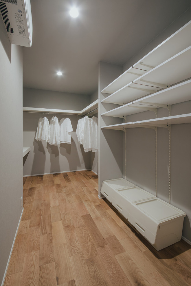 Idee per armadi e cabine armadio contemporanei con pavimento in legno massello medio, pavimento beige e soffitto in carta da parati