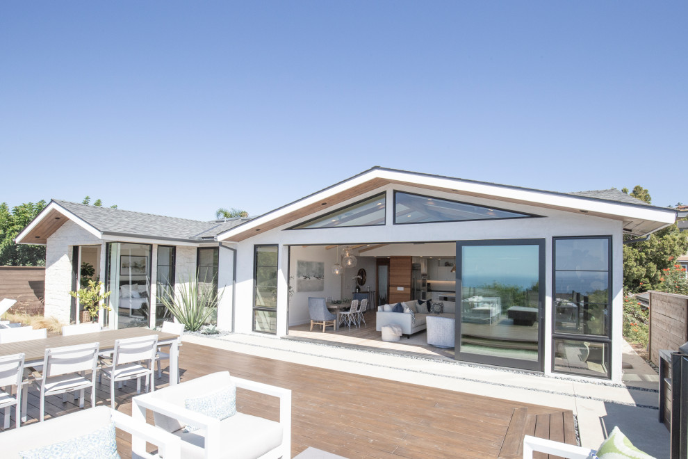 Example of a transitional backyard deck design in Orange County with a fire pit
