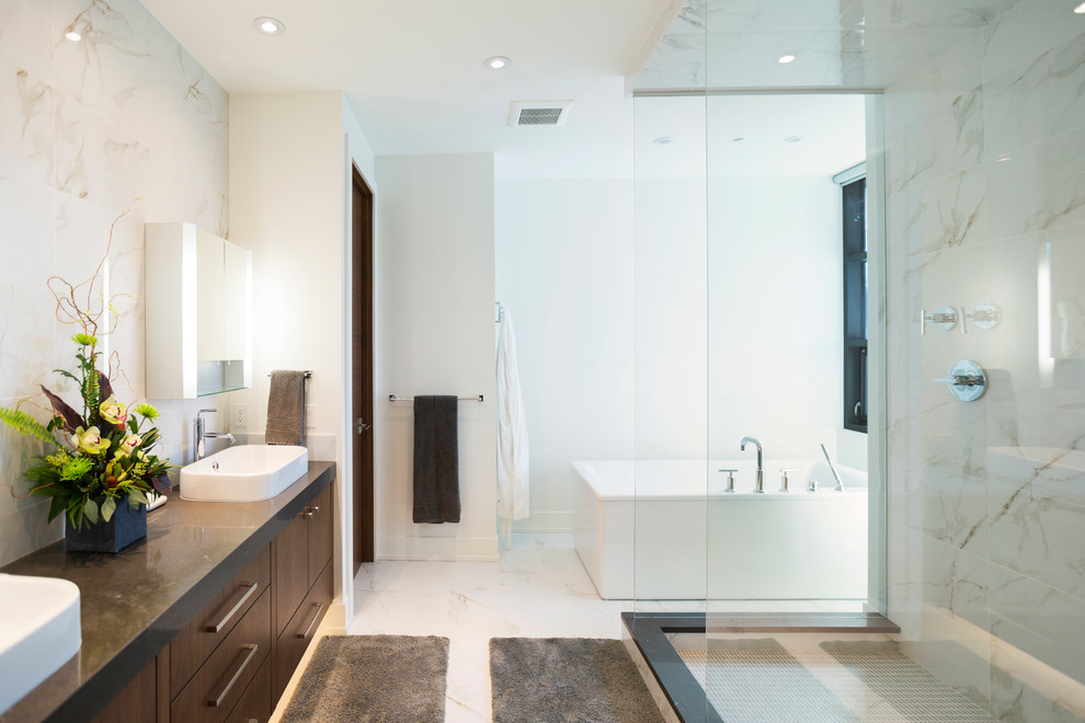 Expansive contemporary master bathroom in Calgary with a vessel sink, flat-panel cabinets, medium wood cabinets, quartzite benchtops, a freestanding tub, an open shower, a two-piece toilet, white tile, porcelain tile, white walls and marble floors.