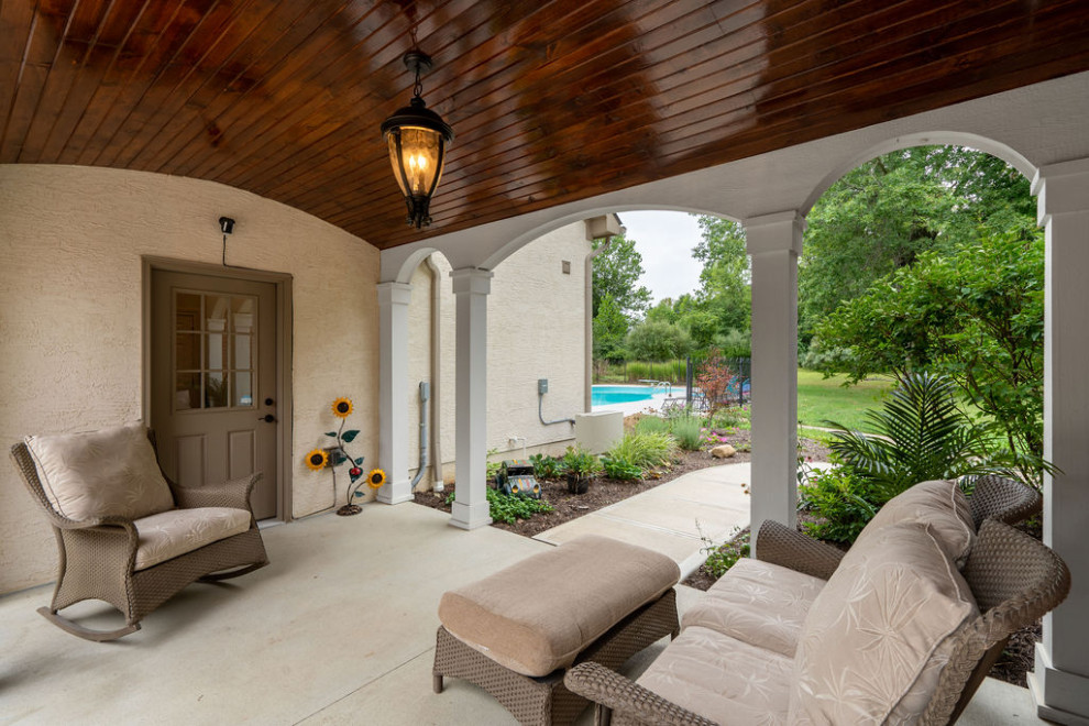 Mid-sized traditional side yard verandah in Columbus with with columns, concrete slab and a pergola.