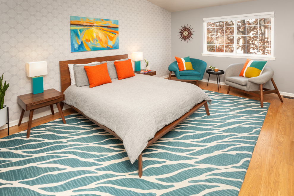 Design ideas for a mid-sized midcentury master bedroom in Detroit with grey walls, light hardwood floors, brown floor, vaulted and wallpaper.