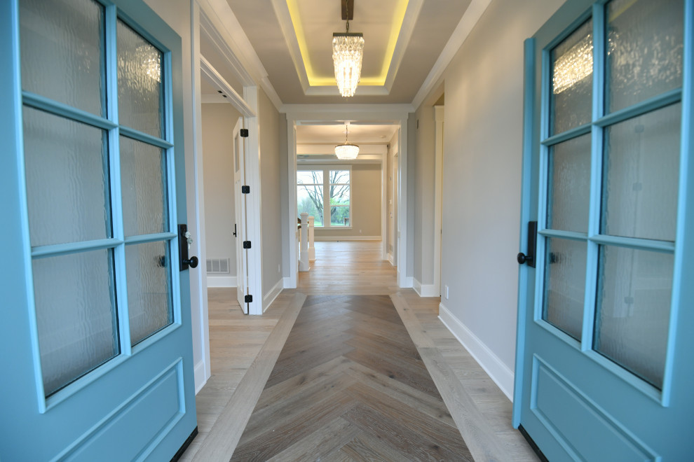 コロンバスにあるトランジショナルスタイルのおしゃれな玄関ドア (白い壁、淡色無垢フローリング、青いドア、折り上げ天井) の写真
