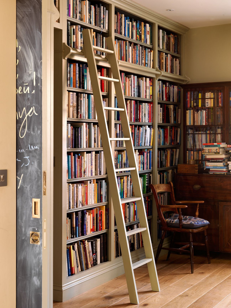 Imagen de despacho clásico de tamaño medio con biblioteca, paredes beige, suelo de madera en tonos medios, escritorio independiente y suelo marrón