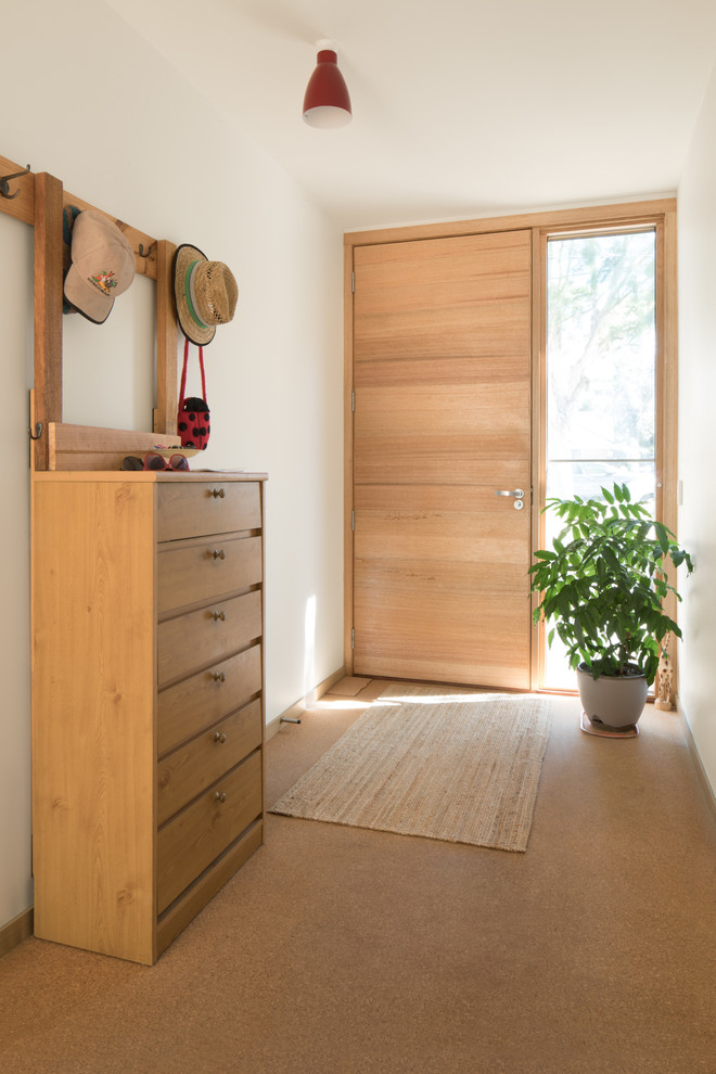 Design ideas for a mid-sized midcentury front door in Melbourne with white walls, cork floors, a single front door, a light wood front door and beige floor.