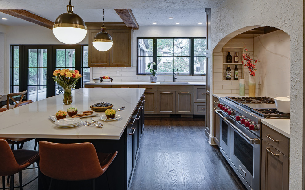 Example of a transitional l-shaped brown floor open concept kitchen design in Chicago with gray cabinets, quartz countertops, white backsplash, quartz backsplash, stainless steel appliances, an island and white countertops