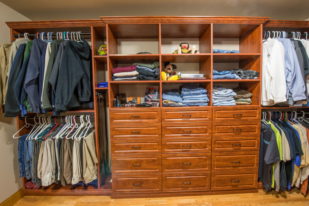 This is an example of a large traditional gender-neutral walk-in wardrobe in Philadelphia with light hardwood floors, shaker cabinets and medium wood cabinets.