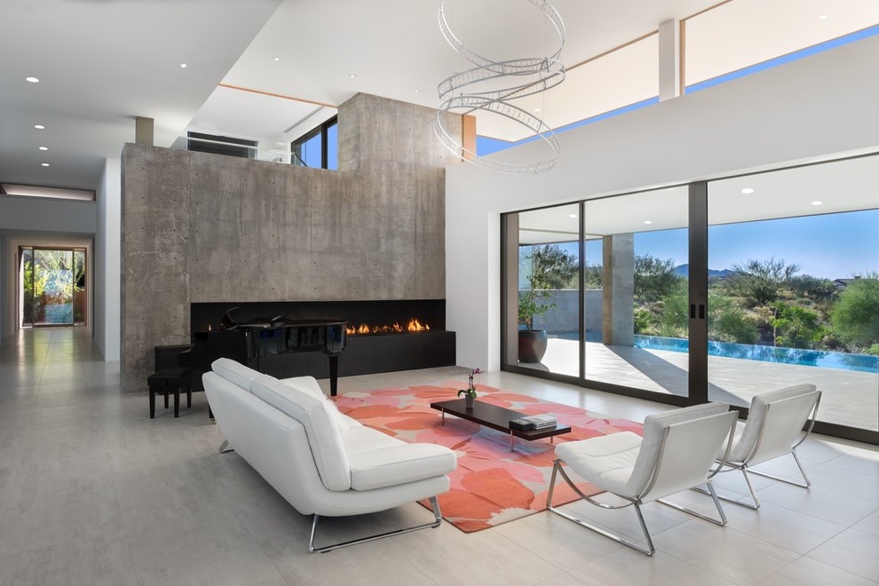 This is an example of a large formal open concept living room in Phoenix with white walls, a ribbon fireplace, a concrete fireplace surround, no tv, concrete floors and grey floor.