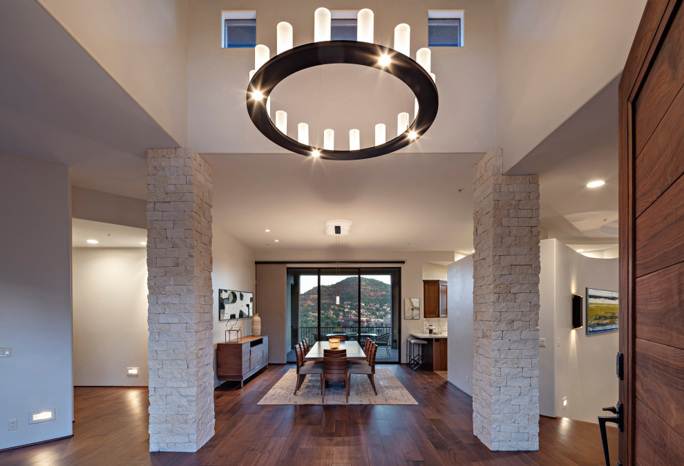 This is an example of a modern entrance in Phoenix with white walls, medium hardwood flooring and brown floors.
